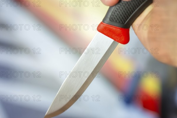 Symbolic image of a knife attack: close-up of a knife in a man's hand