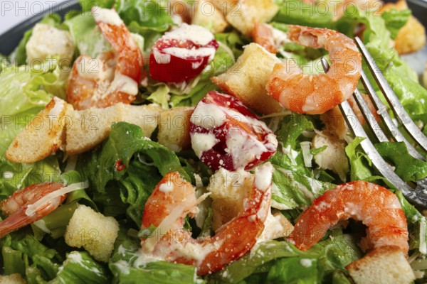 Caesar salad, with shrimp, on a marble background, top view, no people