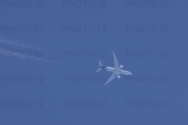 Airbus A300 jet aircraft of Fedex airlines flying in a blue sky with a vapor trail or contrail