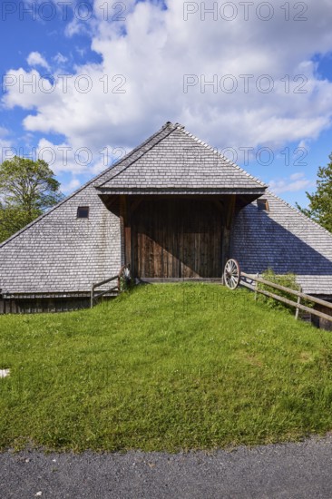 Driveway into a Black Forest house with an old wagon wheel of the Resenhof Farm Museum in the