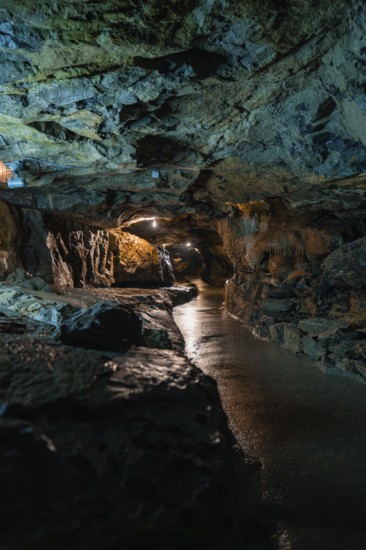 Dark cave made of rocks with water and artificial lighting, mysterious atmosphere, Beatus Caves,
