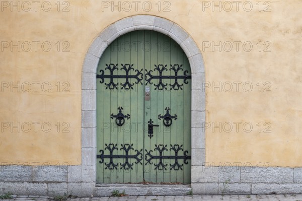 Green wooden door with black, iron fittings and round arch, Old Town, Hanseatic City of Visby,