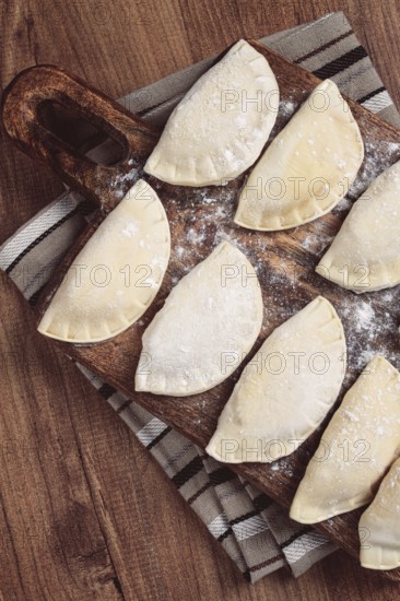 Traditional Polish dish, dumplings, raw, frozen, on a cutting board, wooden table, top view, no