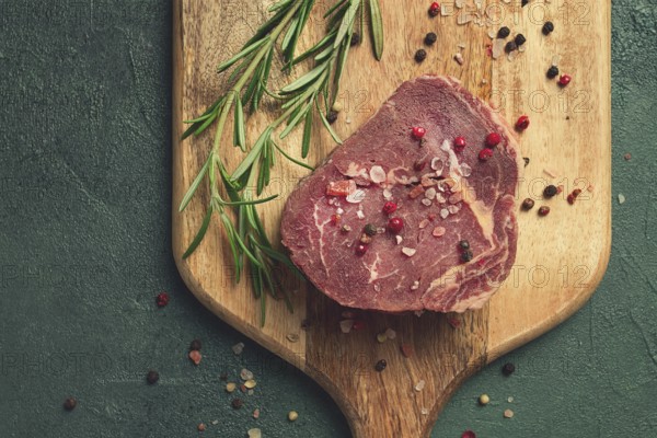 Fresh, raw rib eye steak, on a chopping board, top view, no people