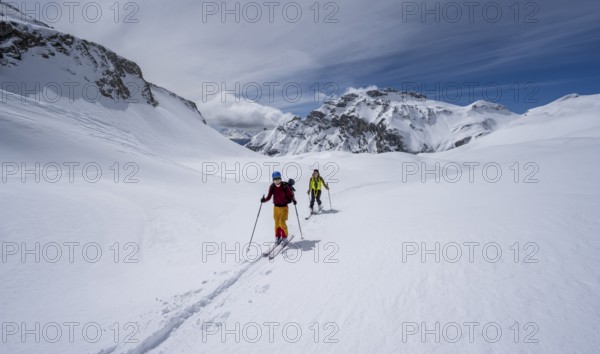 Ski tourers in a mountain landscape with snow, summit Wildhorn in the background, ascent to
