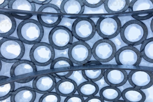 Surface of metal rings, partially covered with snow, detail of the art installation Wunderhorn by