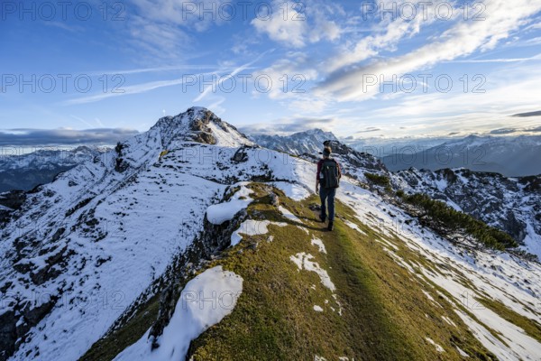 Mountaineer on hiking trail, mountain landscape with snow in autumn, summit and ridge of the