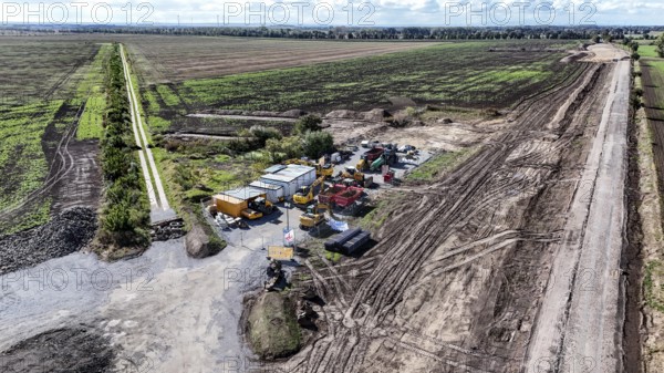 Construction vehicles are parked on an access road under construction to the High Tech Park at the