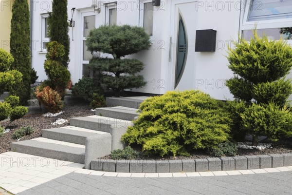 Well-kept front garden with block steps, ornamental stones and planting