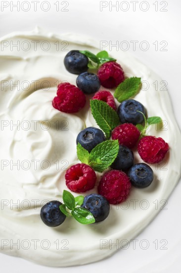 Breakfast, yogurt with fresh berries, raspberries and blueberries, on a white background, selective