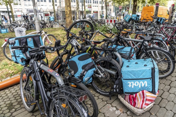 Wolt delivery service, parked bikes of bicycle couriers with thermal backpack, in front of the main