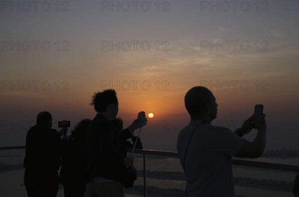 Tourists take selfie with smartphone, selfie stick, The View At the Palm, Palm Jumeirah, sunset,