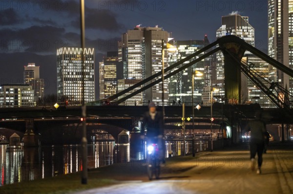 Skyline of the city centre of Frankfurt am Main, cyclist with light on the cycle path, pavement,