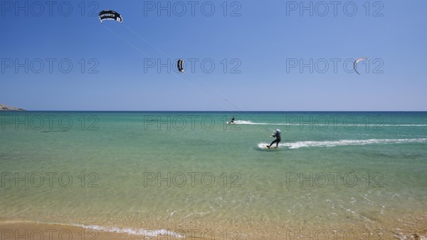 Kitesurfer on turquoise blue sea near the beach under a clear blue sky, surfers paradise,