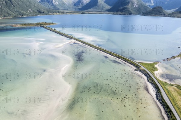 Aerial view of a bridge over turquoise sea at a sandy beach, fjord Grunnforfjorden, Lofoten