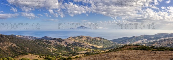 Panoramic view of hilly landscape by the sea under a blue sky, near Tarifa, view to Morocco
