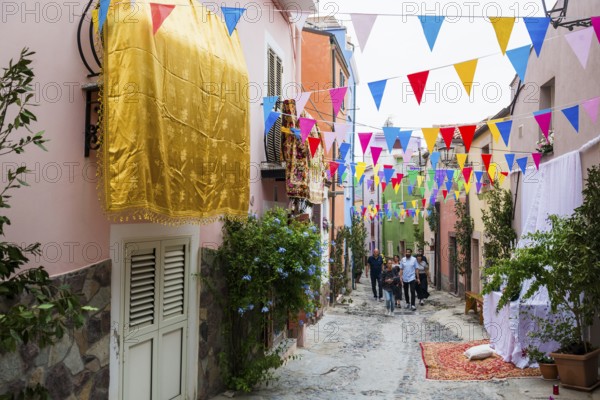 Decorated alley and celebrating people, feast of the Madonna of Regnos Altos, Bosa, district of