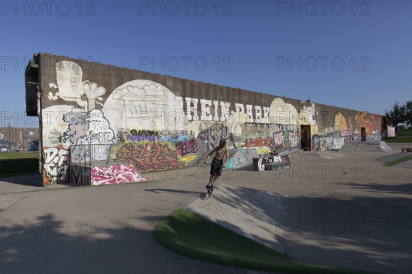 Rehinpark Duisburg, skate park with graffiti wall, boy jumping with stunt scooter, Duisburg, North