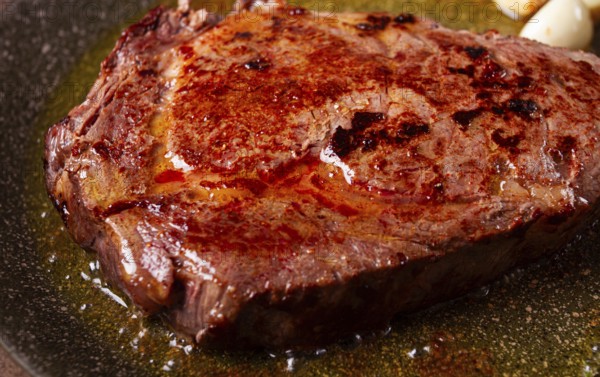 Fried steak, beef steak, rib eye steak, in a frying pan, top view, no people