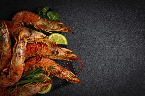 Langoustines, Australian, freshly frozen on ice, top view, lime and greens