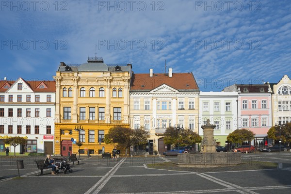 Urban street with historic buildings and a fountain under a clear sky, Ceská Lípa, Bohemian Leipa,
