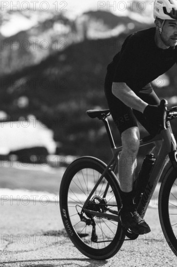 Road bike rider in spring in the Allgäu against the picturesque backdrop of the Alps, Bavaria,