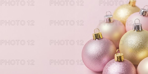 Christmas banner with pink and yellow bauble ornaments on pink background with copy space.