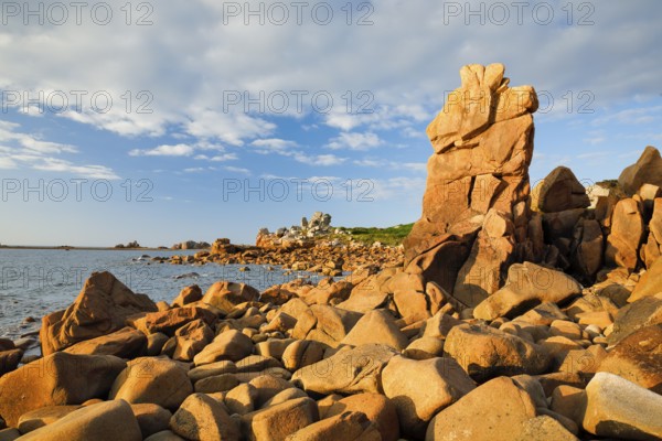 Striking orange-coloured rock formations in the evening light, on the coast of the English Channel