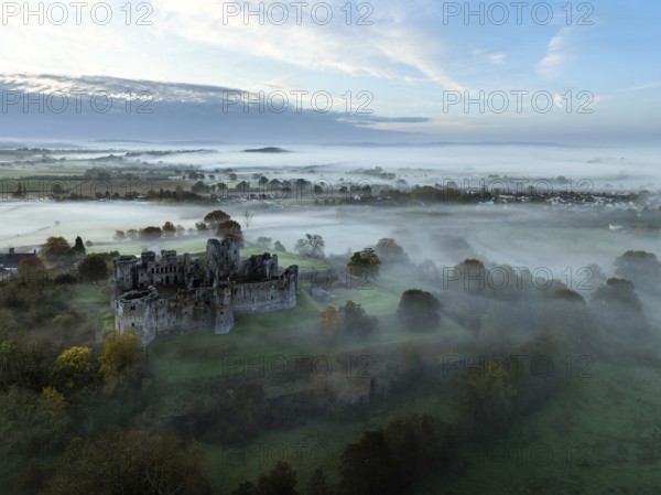 Raglan Castle in the fog at dawn from a drone, Monmouthshire, Wales, England, United Kingdom,