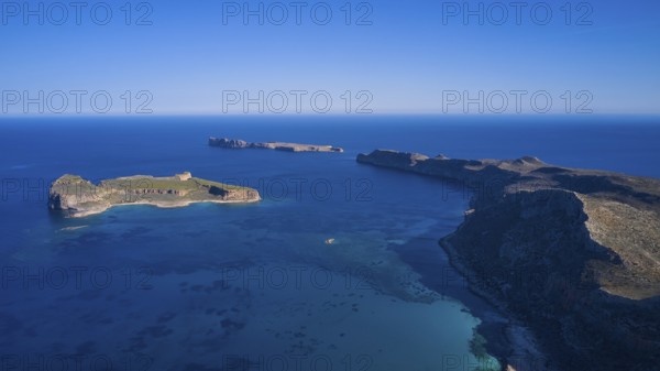Drone shot, panoramic view of two islands, one with green vegetation and one rocky, surrounded by