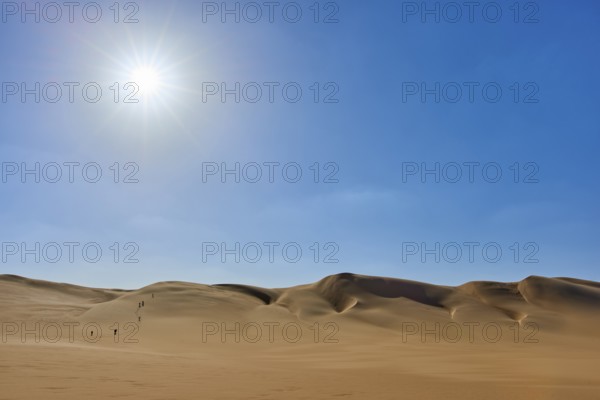 Sunny desert landscape with sand dunes tourist group, under clear blue sky, Matruh, Great Sand Sea,