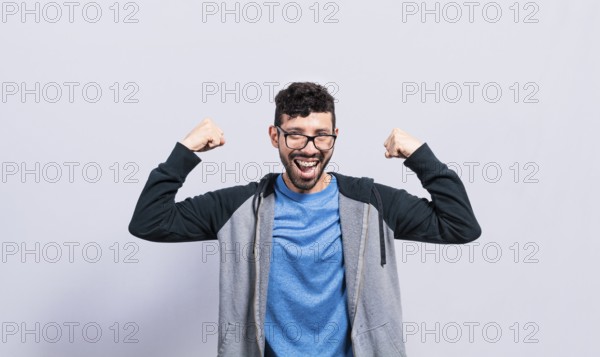 Young man with happy face raising arms in victory gesture isolated. Winner person celebrating