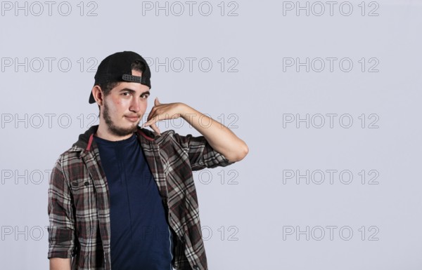 Man making phone gesture with his fingers, Hispanic young man making phone gesture and pointing to
