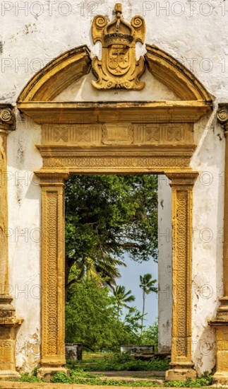 Baroque church portal overlooking tropical vegetation and ruins in the city of Olinda in