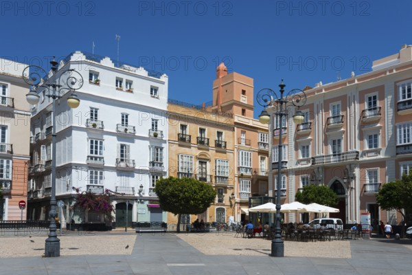 Urban square with colourful historic buildings and trees under a blue sky, Plaza de San Antonio,
