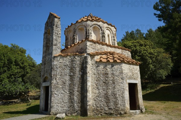A historic stone church with a blue sky and surrounded by nature, Byzantine Chapel of Agios