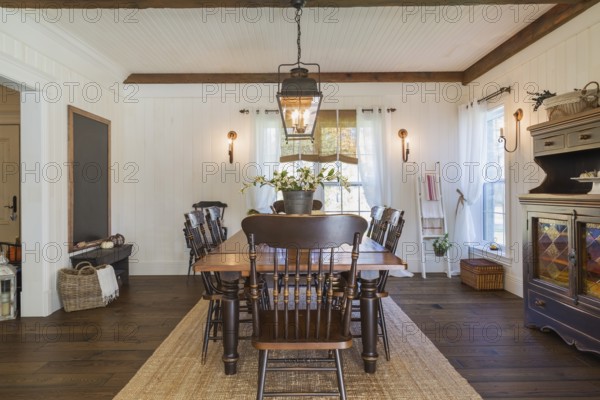 Brown stained pine wood antique reproduction style dining table with high back chairs in dining