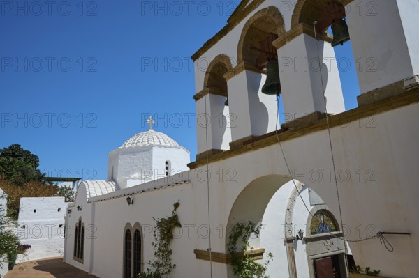 Cross-domed church Diasososuan, White church with a bell tower and several arches, blue sky in the