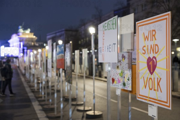Signs painted by children with the words Menschen machen Freiheit and Wir sind 1 Volk to mark the