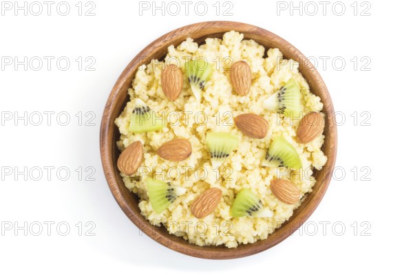 Millet porridge with kiwi and almonds in wooden bowl isolated on white background. Top view, flat