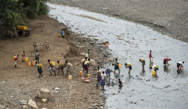 Women and girls fetch water in plastic canisters from a river near the road from Arba Minch to