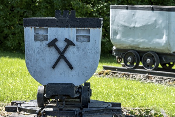 Trolleys for transporting brown coal underground, mining, mine wagon with hammer and iron symbol,