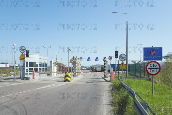 Customs station with open barrier and traffic signs on a sunny day, border from Poland to Ukraine,