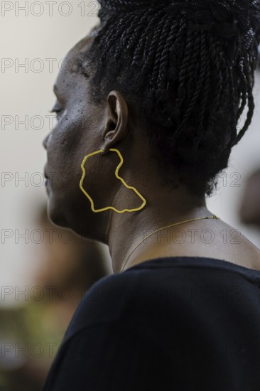 Woman wearing an earring showing the outline of the continent of Africa, Berlin, 07.03.2024