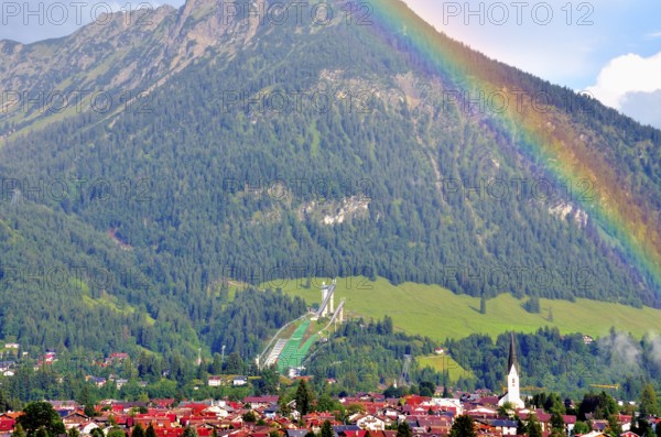 View over Oberstdorf with rainbow, behind it the Schattenberg with Schattenbergschanze, Oberallgäu,