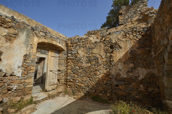 A crumbling building with open doors and stone walls standing in daylight, Venetian Sea Fortress,