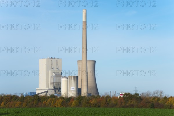 Industrial plant with chimney and cooling tower in autumn landscape under blue sky, Mehrum