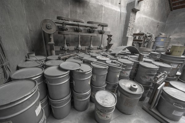 Metal barrels covered with zinc dust in the filling room for zinc powder of a metal powder mill,