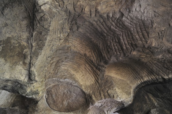 Grooves and circles in the sandstone rock from carving millstones at the Hohllay cave in Berdorf,