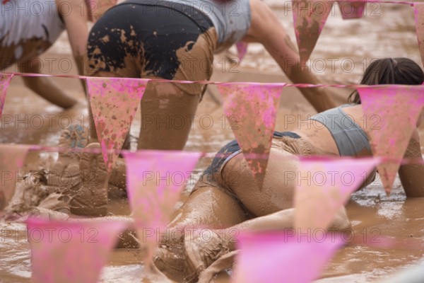 Group of participants in a muddy outdoor obstacle course